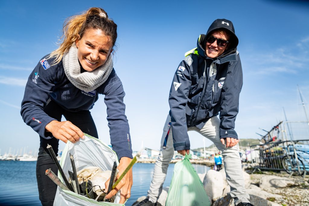 British Sailing Team collecting litter from a beach during a sailing event