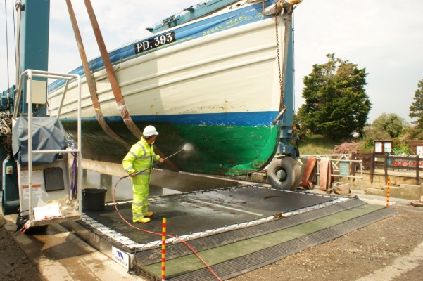 A person cleaning the hull of a boat