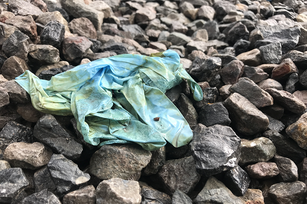 A rag stained with antifoul lying on a stony beach