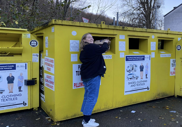 A women disposing of waste at a recycling bin