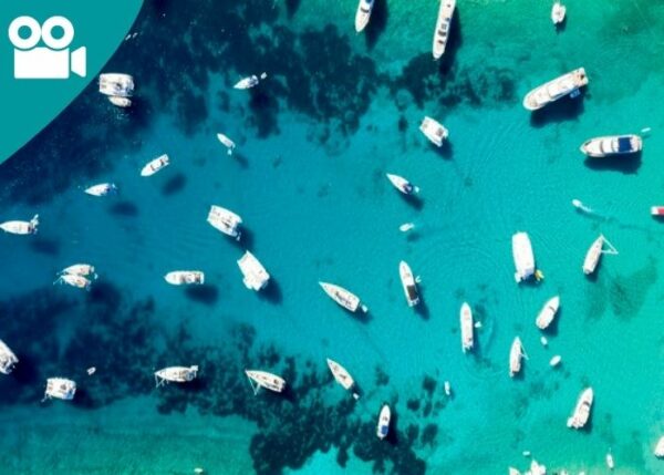 Boats moored in a blue sea, seen from above