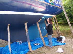 A woman anti-fouling her boat following best practice guidance