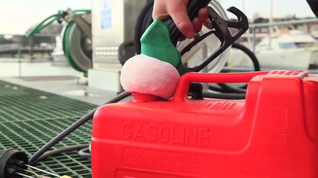 Filling a red fuel container with a fuel nozzle