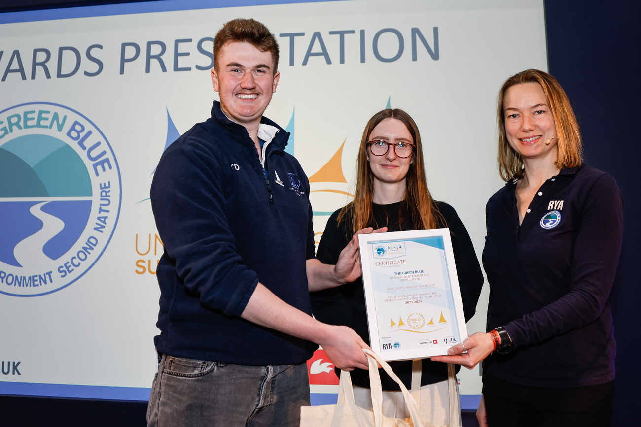 Two students collect their club's certificate from Kate Fortnam.