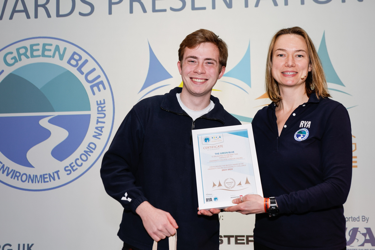 A student collects his club's certificate from Kate Fortnam.